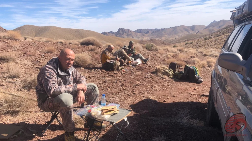 Hunters taking a lunch break in Iran’s desert highlands beside a 4×4, hunt in Iran