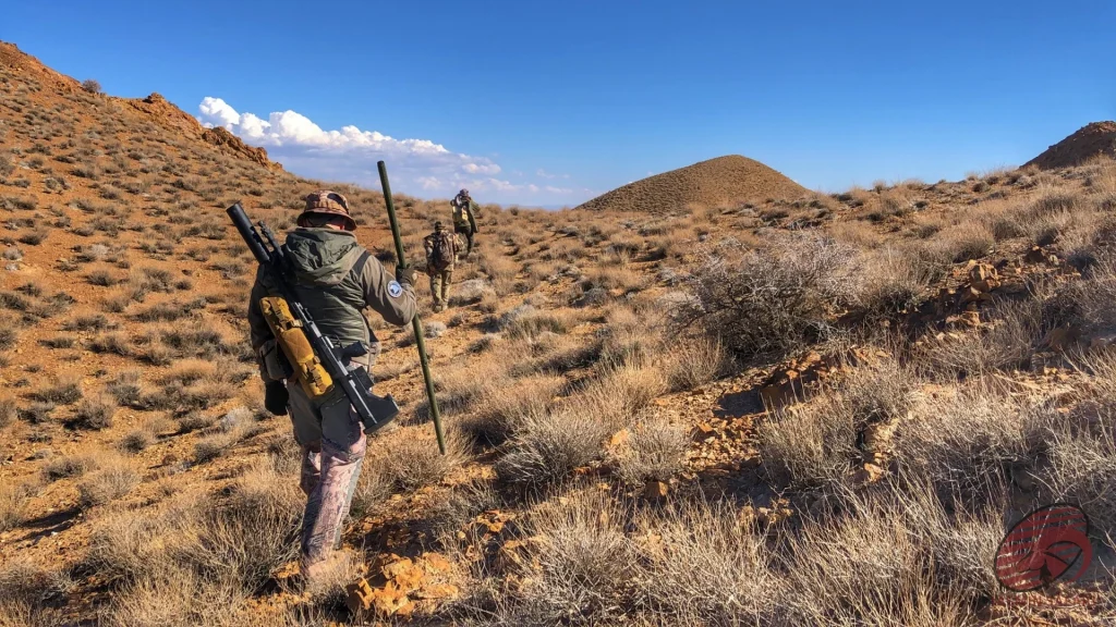 Hunters descending a rocky ridge across a vast highland vista in Iran, hunt in Iran
