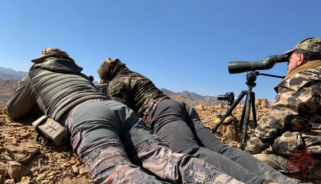 Hunters glassing distant ridges with a spotting scope on a rocky mountain in Iran,